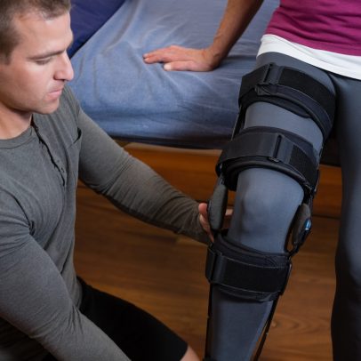 Physiotherapist examining his patients knee in clinic