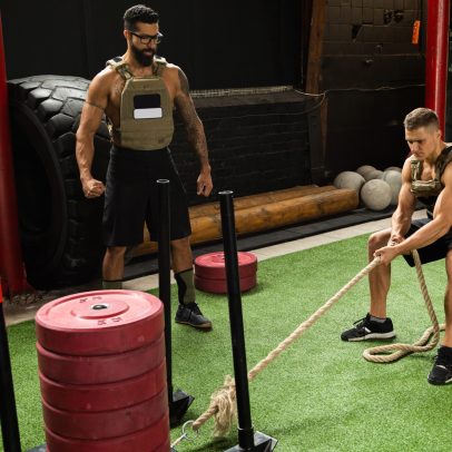 Strong sportsman during his cross training workout. Sled drag exercise.